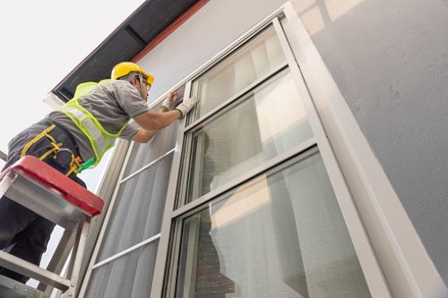 Man on Ladder Installing Window Film
