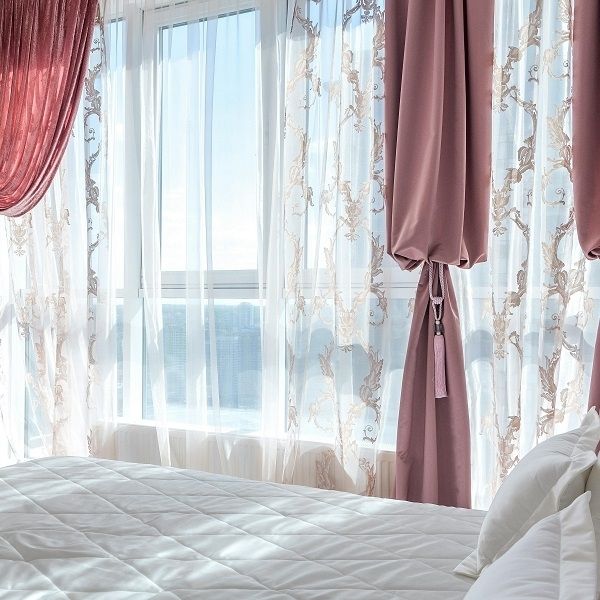 Sun and heat coming through windows with drapes.