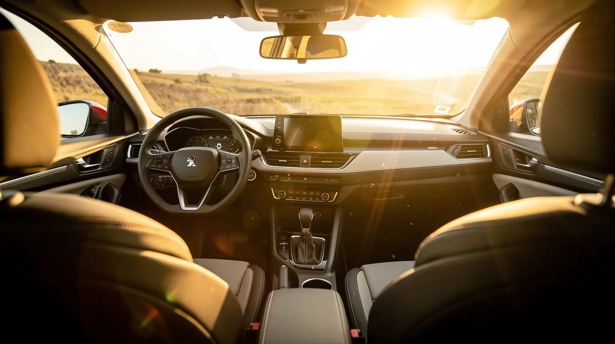 A car cabin flooded with bright sunlight streaming through the side windows, highlighting the interior's features. The light conditions suggest the potential for harmful UV rays, emphasizing the benefits of photochromic window tint that can block these rays while enhancing visibility and controlling glare.