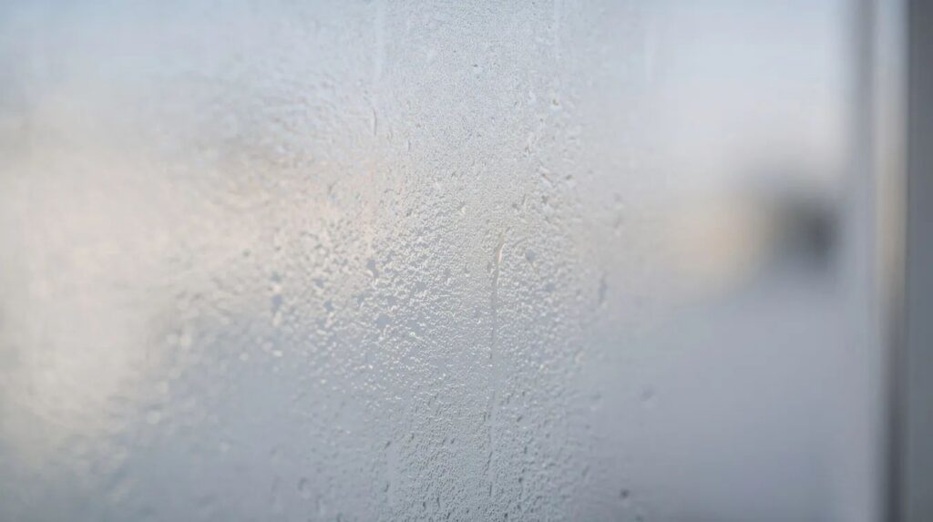 A close-up view of frosted glass on a bathroom window allows soft daylight to filter through, creating a serene atmosphere while providing instant privacy. This type of glass can be enhanced with residential window film for added UV protection and glare reduction, ensuring a comfortable and energy-efficient space.